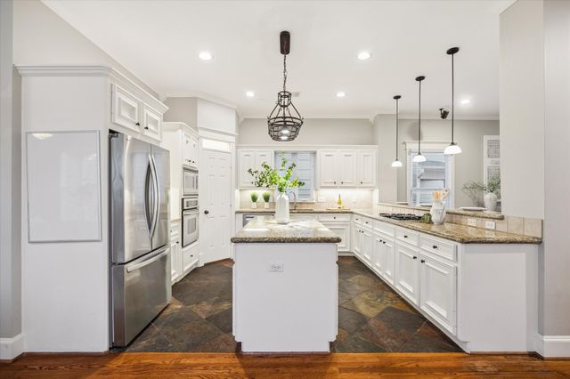 a kitchen with white cabinets and sink