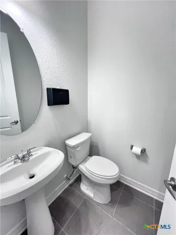 a bathroom with a toilet a sink and mirror