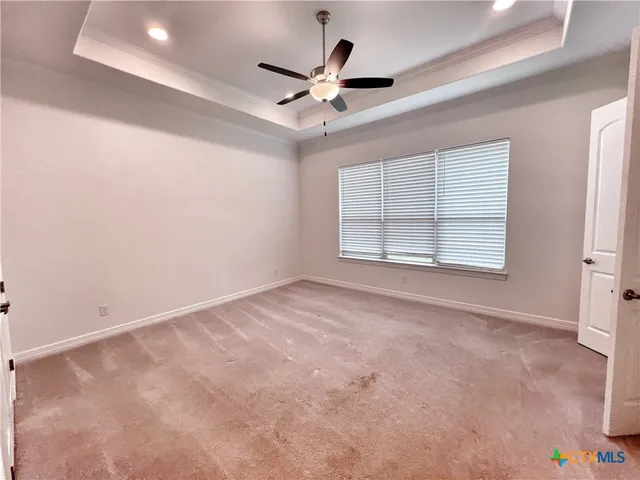an empty room with ceiling fan and window