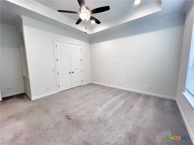 an empty room with a ceiling fan and a window