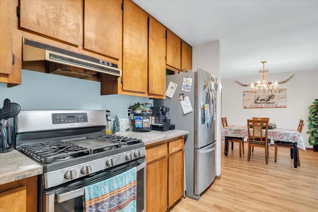 a kitchen with stainless steel appliances granite countertop a stove a sink and a refrigerator