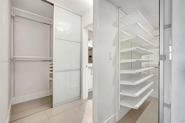 a view of walk in closet with empty racks