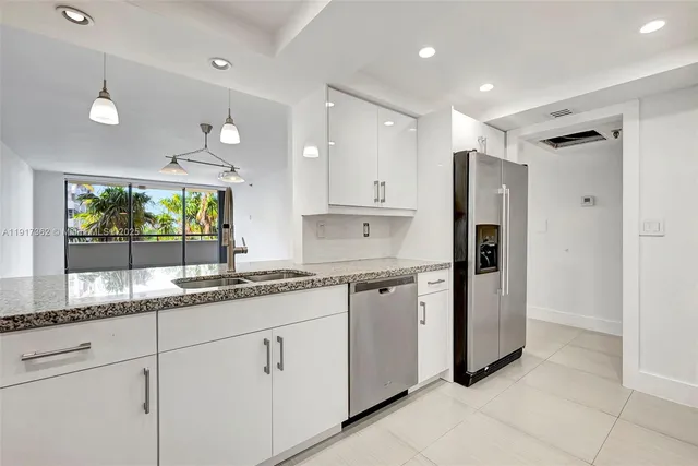 a kitchen with granite countertop white cabinets and white appliances