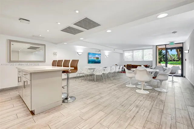 a kitchen with stainless steel appliances granite countertop a stove a sink a refrigerator and white cabinets with wooden floor