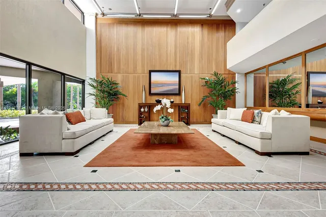 a living room with furniture kitchen view and large windows
