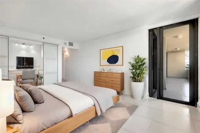 a bedroom with a bed and flat screen tv