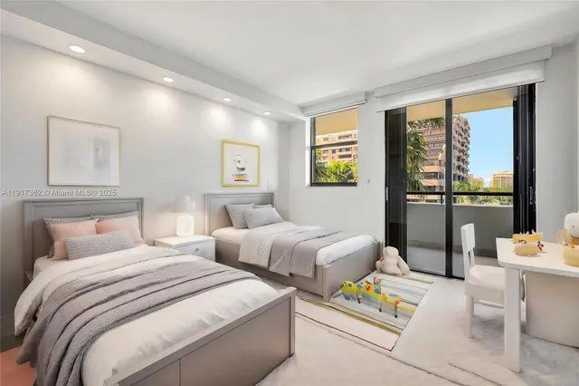 a bedroom with two beds and a large window