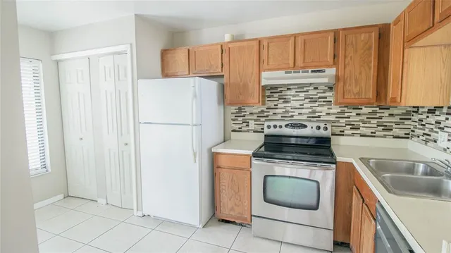 a kitchen with a stove top oven sink and refrigerator