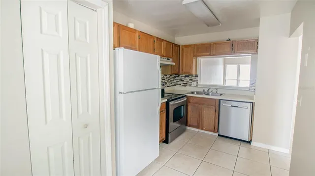 a kitchen with a refrigerator a stove top oven and cabinets