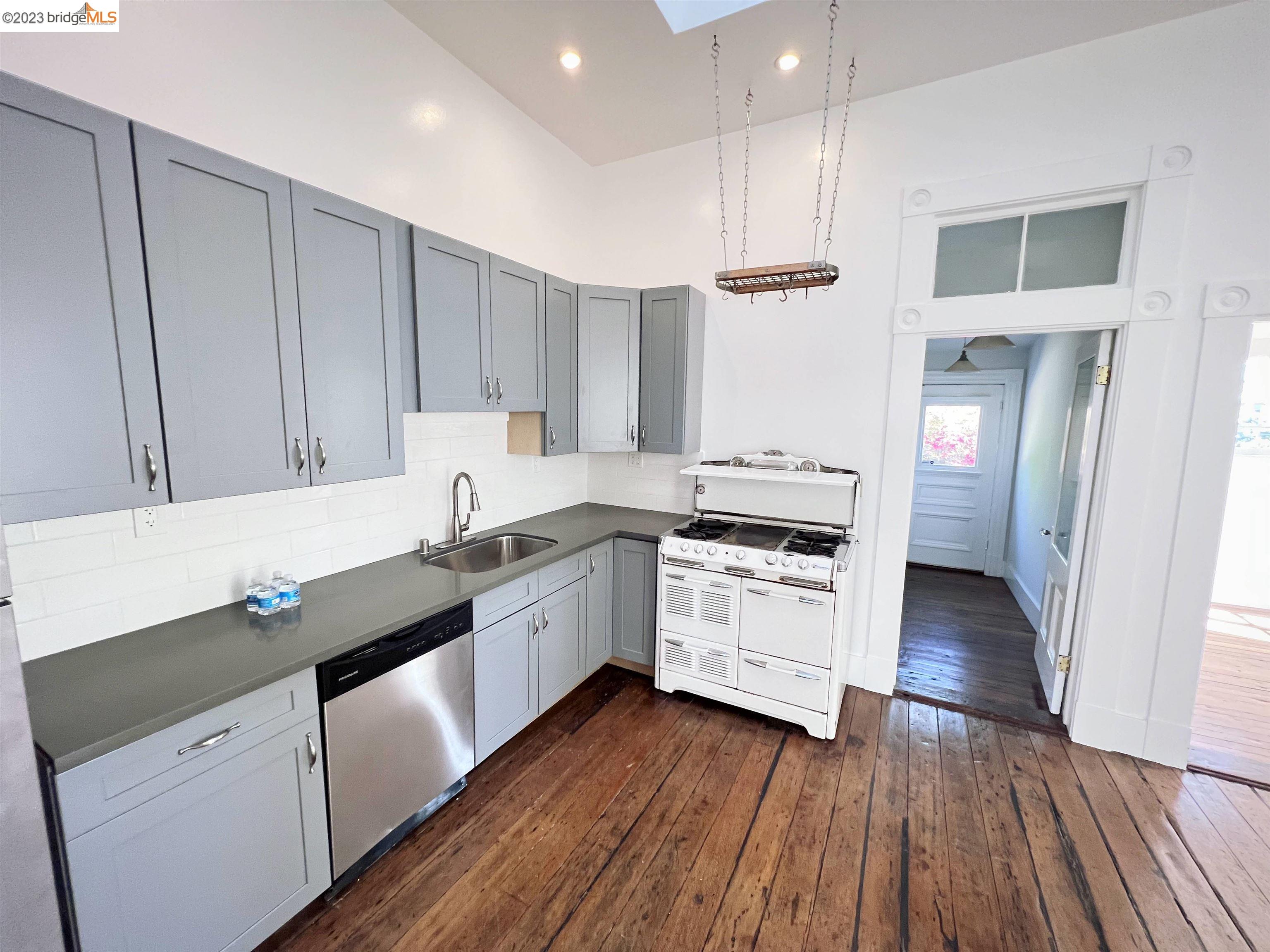 a kitchen with wooden floors and white appliances