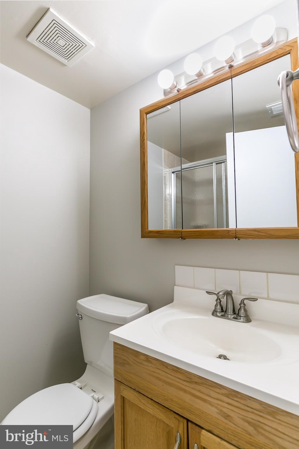 11650 Stoneview Square, Unit 11C Reston, VA 20191 - Photo 16 of 26 a bathroom with a sink a toilet and mirror