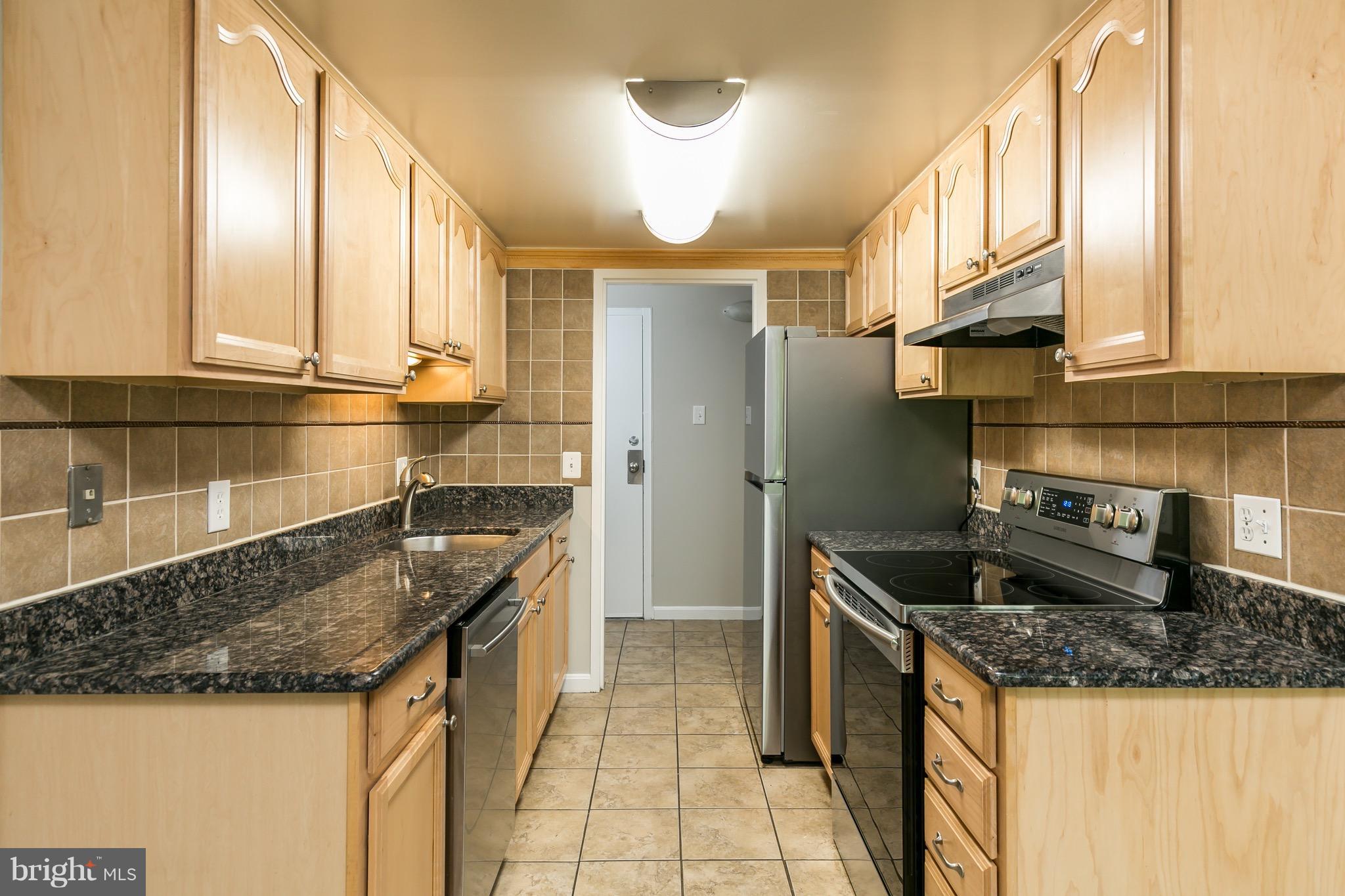 11650 Stoneview Square, Unit 11C Reston, VA 20191 - Photo 3 of 26 a kitchen with granite countertop a sink and a refrigerator