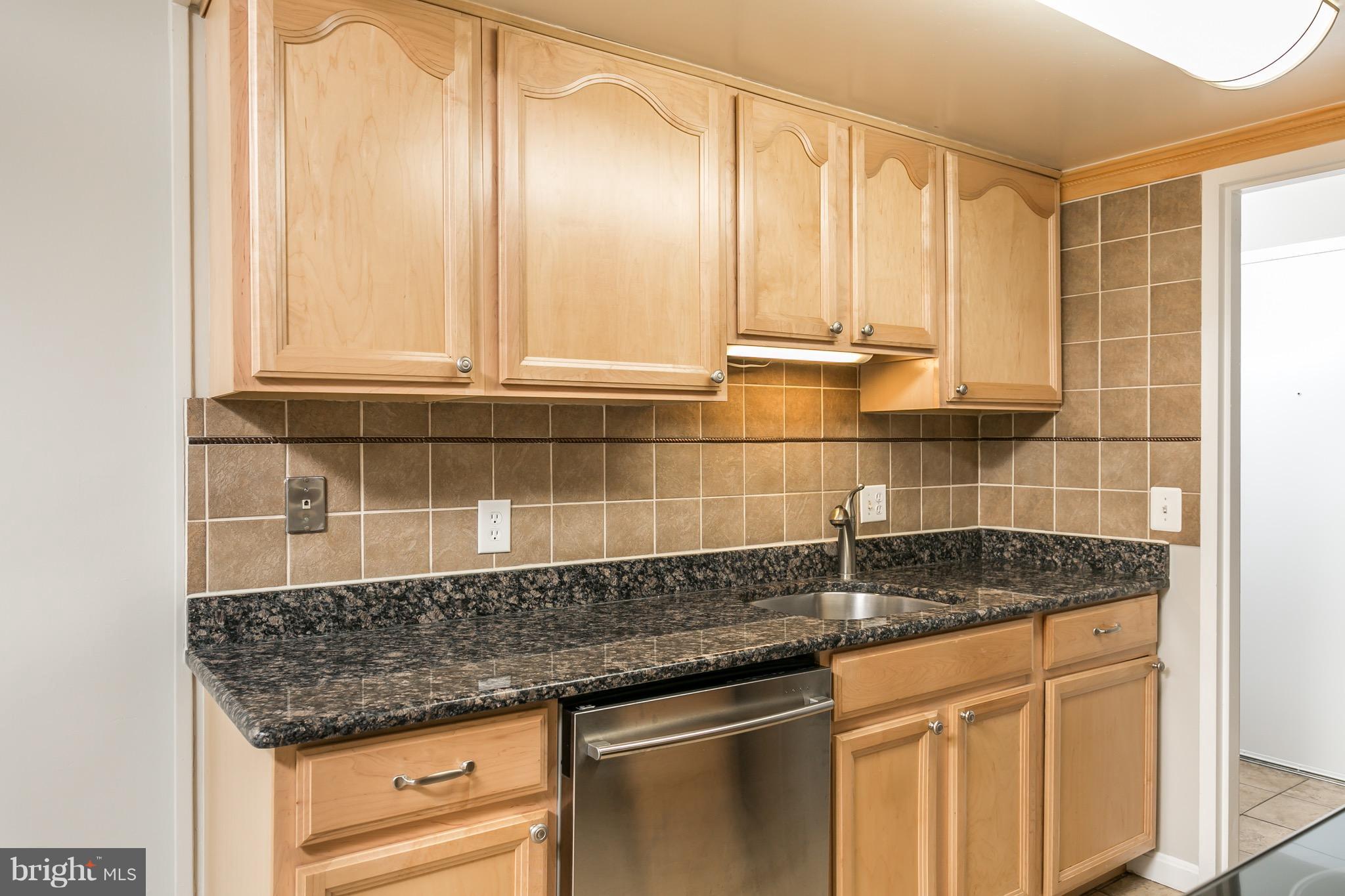 11650 Stoneview Square, Unit 11C Reston, VA 20191 - Photo 5 of 26 a kitchen with granite countertop a sink and a white cabinets