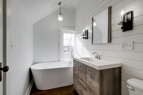 a bathroom with a sink a toilet a mirror and shower