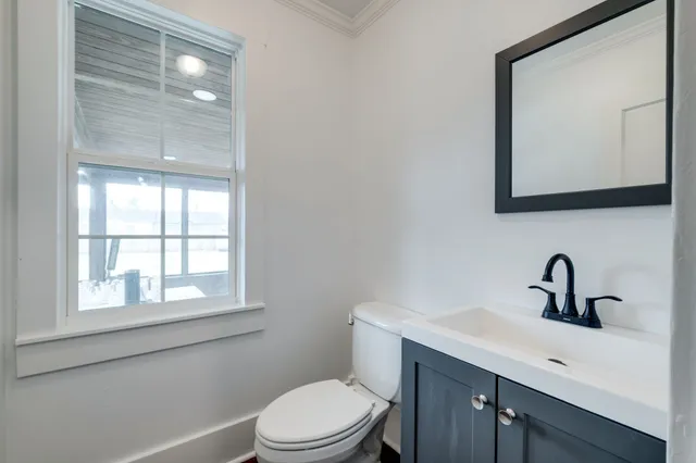 a bathroom with a toilet a sink a vanity and mirror