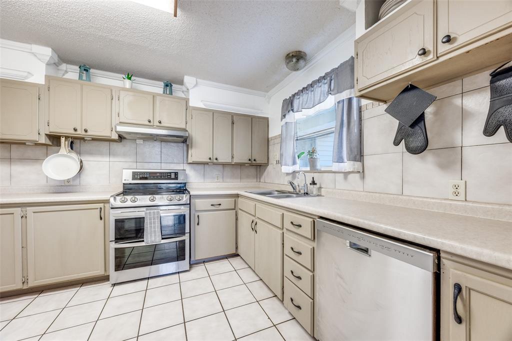 4440 Dripping Spring Road Sherman, TX 75090 - Photo 8 of 39 a kitchen with white cabinets and white appliances
