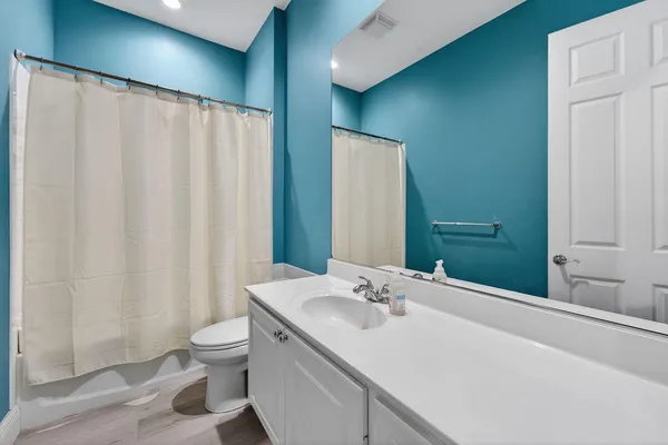 a bathroom with a sink a toilet and shower curtain