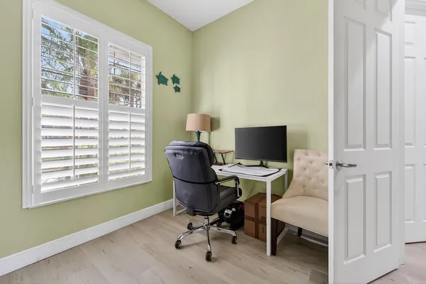 a view of a workspace with furniture and a window