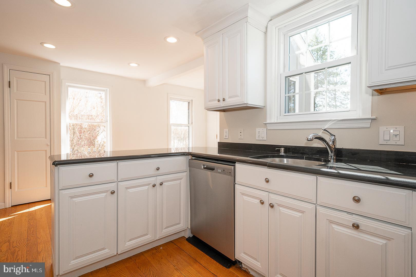 128 Homestead Road Wayne, PA 19087 - Photo 12 of 30 a kitchen with granite countertop white cabinets and a window