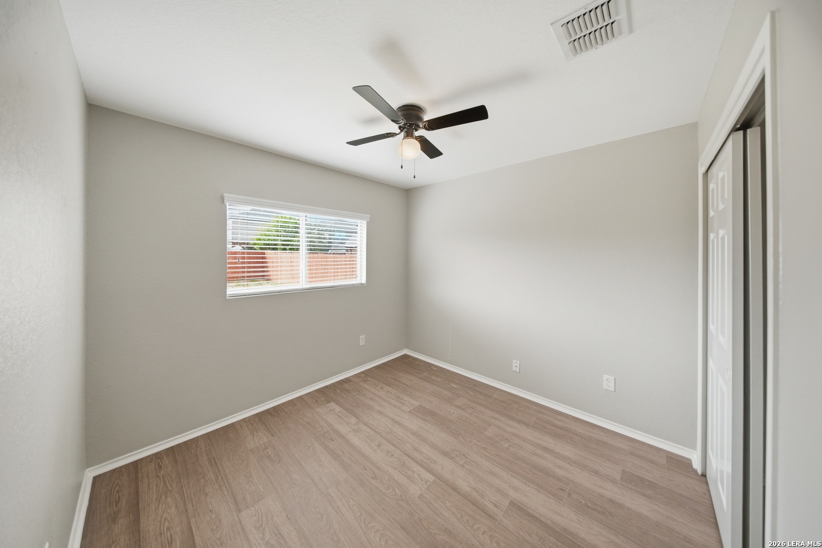 403 Walnut Crest Schertz, TX 78154 - Photo 13 of 30 an empty room with wooden floor ceiling fan and windows