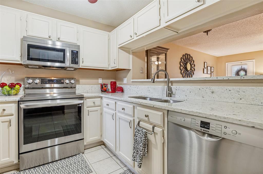 22 Abbey Road Euless, TX 76039 - Photo 10 of 23 Kitchen features granite counter tops, deep stainless steel sink, stainless steel appliances- electric range, built in mircowave.