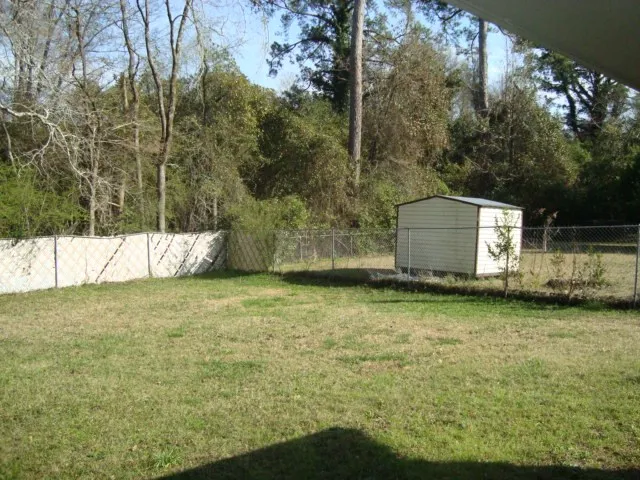 a backyard of a house with a garden and tree