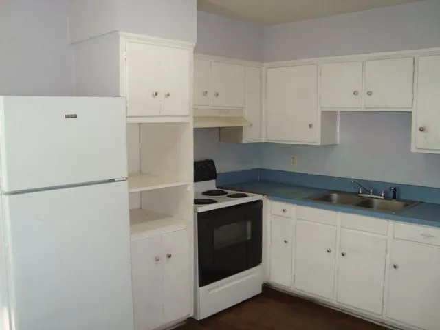 a kitchen with white cabinets and white appliances