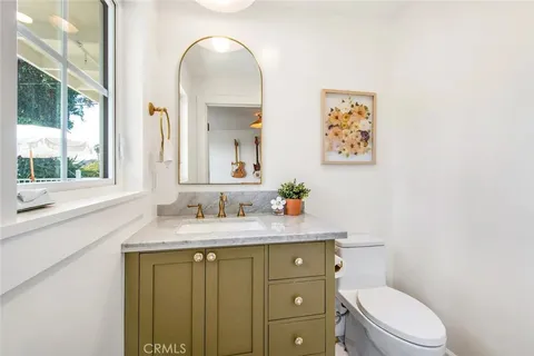 a bathroom with a granite countertop toilet sink and mirror