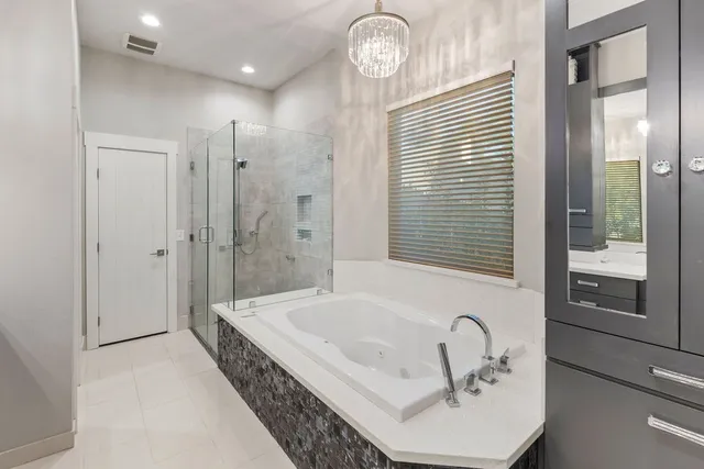 a bathroom with a tub sink and mirror