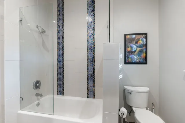 a white toilet sitting next to a bath tub