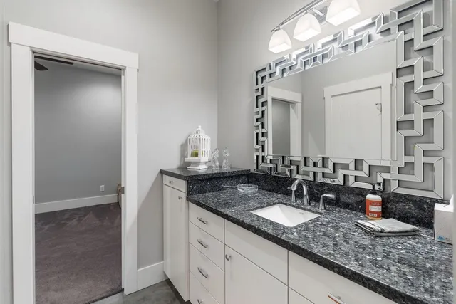 a bathroom with a granite countertop sink and a mirror