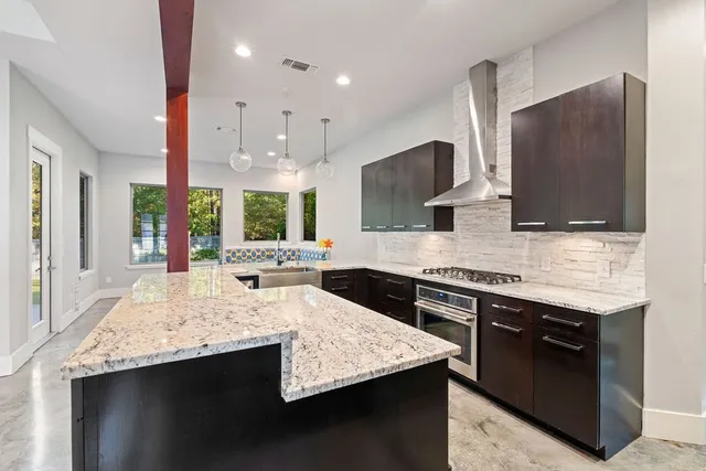 a kitchen with stainless steel appliances granite countertop a sink stove and refrigerator