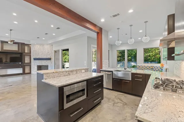 a large kitchen with stainless steel appliances granite countertop a stove and large cabinets