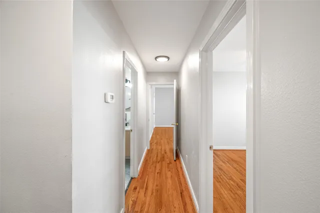 a view of a hallway with wooden floor