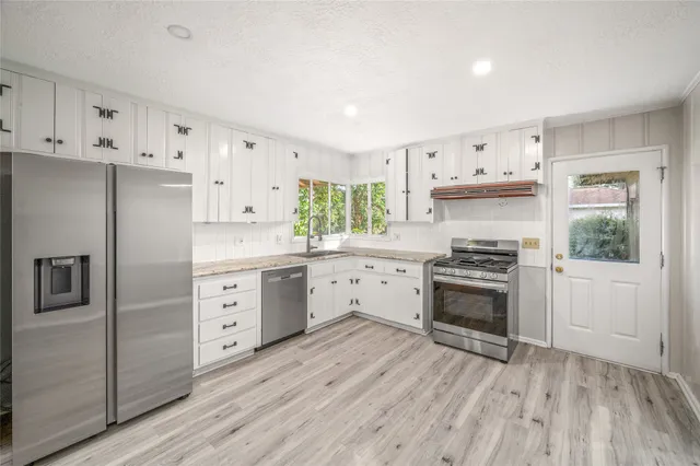 a kitchen with stainless steel appliances a stove a sink and a refrigerator