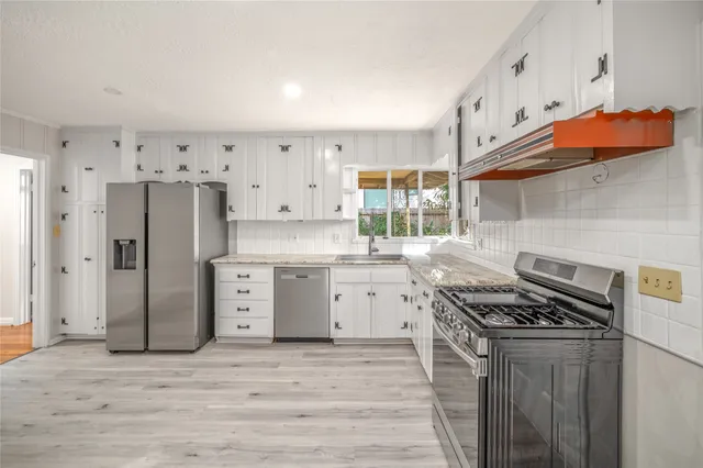 a kitchen with stainless steel appliances a stove a sink and a refrigerator