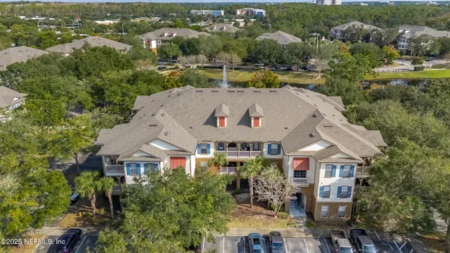 a backyard of a house with large trees and plants