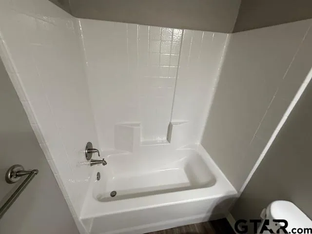 a bathroom with a tub and toilet