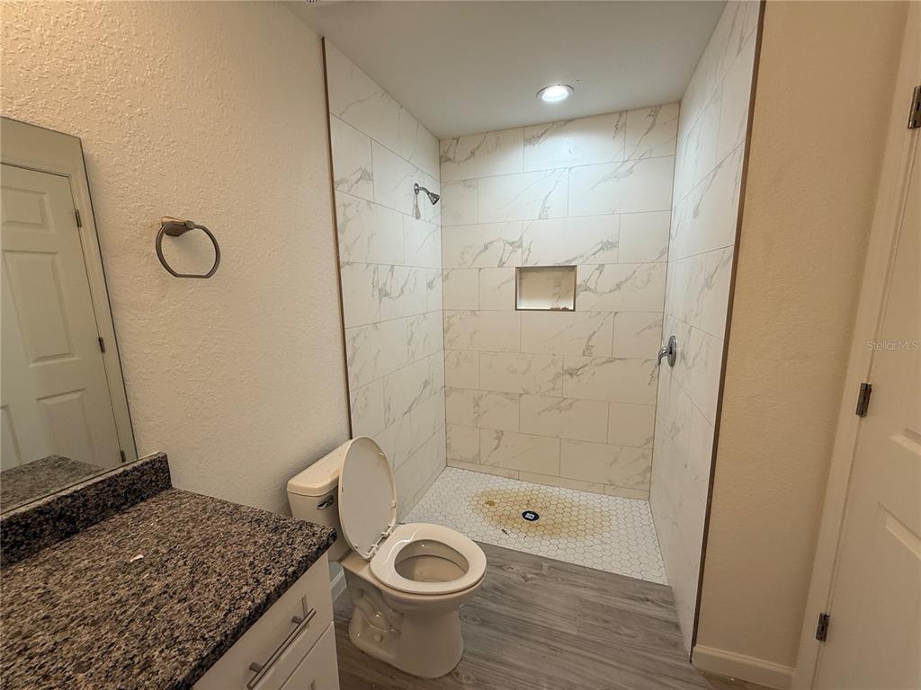 5358 Rhapsody Avenue North Port, FL 34288 - Photo 11 of 28 a bathroom with a granite countertop sink a toilet and shower