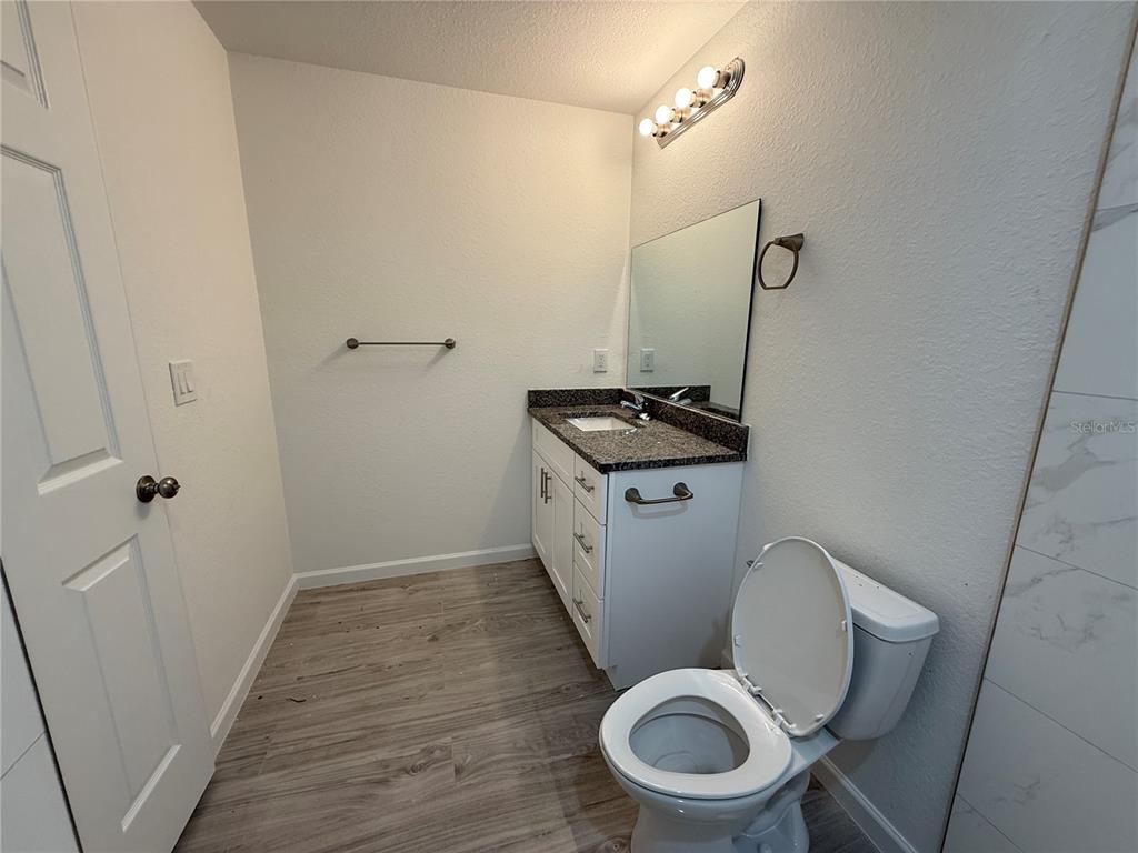 5358 Rhapsody Avenue North Port, FL 34288 - Photo 12 of 28 a white toilet sitting next to a sink and vanity