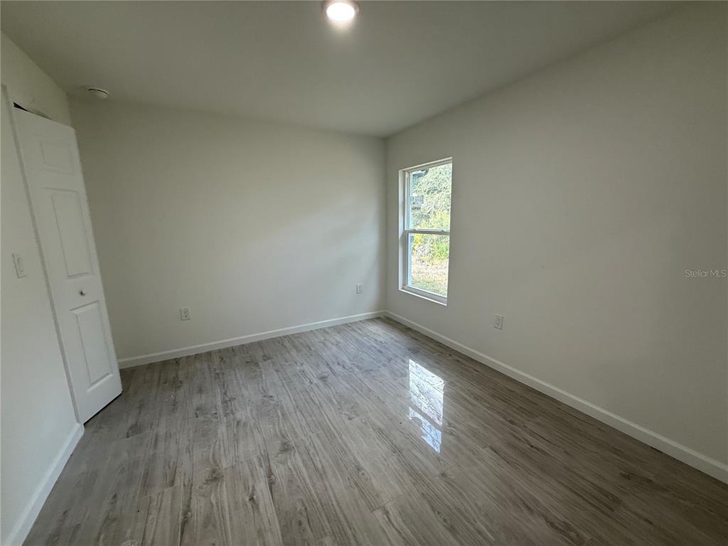 5358 Rhapsody Avenue North Port, FL 34288 - Photo 14 of 28 an empty room with wooden floor and windows