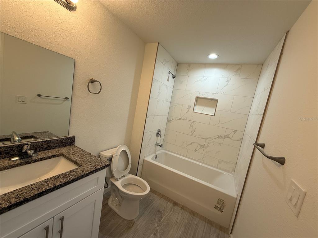 5358 Rhapsody Avenue North Port, FL 34288 - Photo 15 of 28 a bathroom with a granite countertop sink toilet and shower