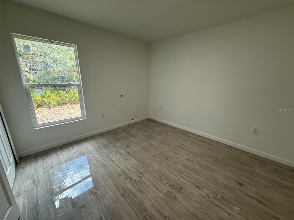 5358 Rhapsody Avenue North Port, FL 34288 - Photo 18 of 28 an empty room with wooden floor and windows