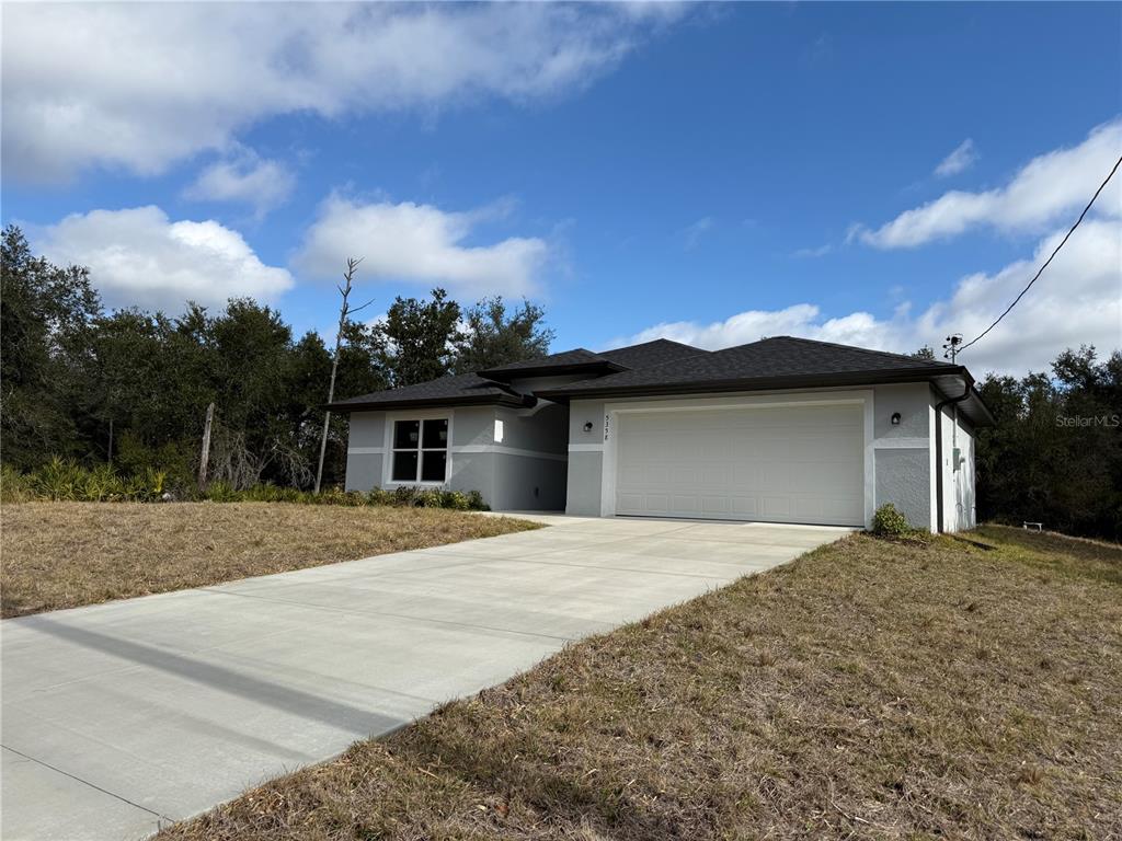 5358 Rhapsody Avenue North Port, FL 34288 - Photo 2 of 28 a front view of a house with a yard and garage