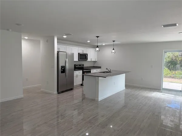 a view of kitchen with refrigerator and microwave