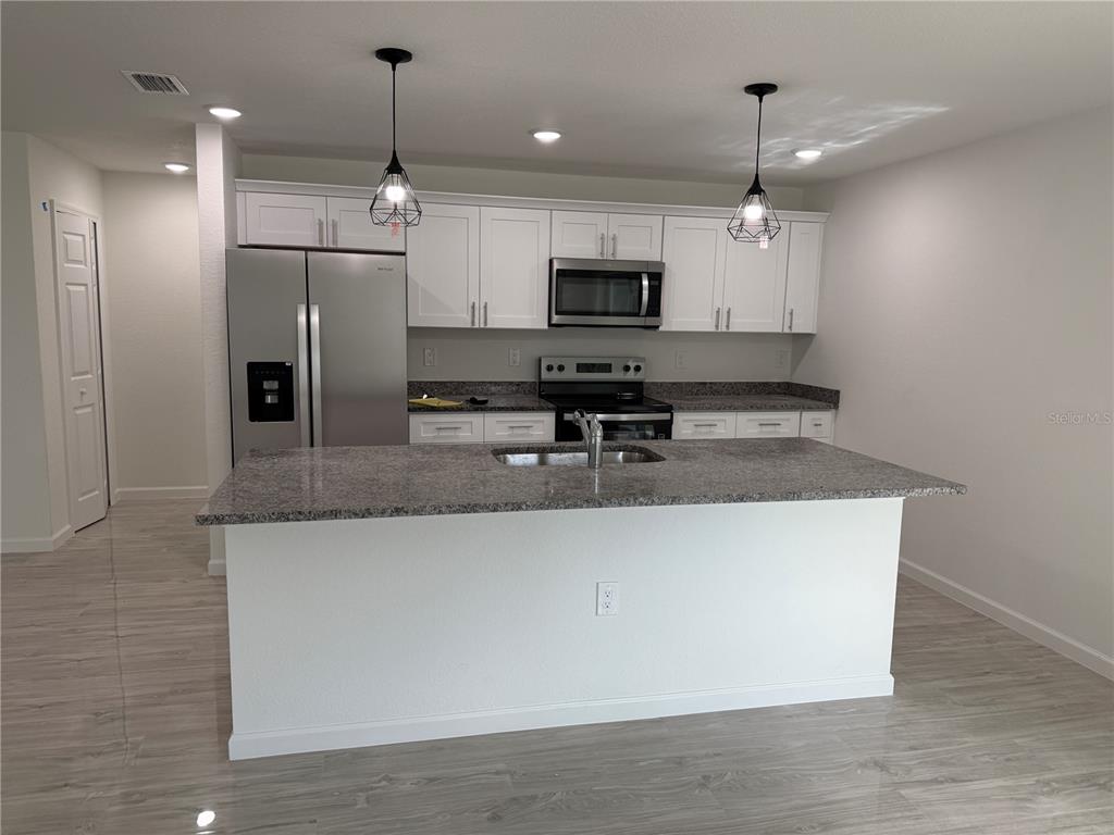 5358 Rhapsody Avenue North Port, FL 34288 - Photo 7 of 28 a kitchen with stainless steel appliances granite countertop a sink a stove and a refrigerator