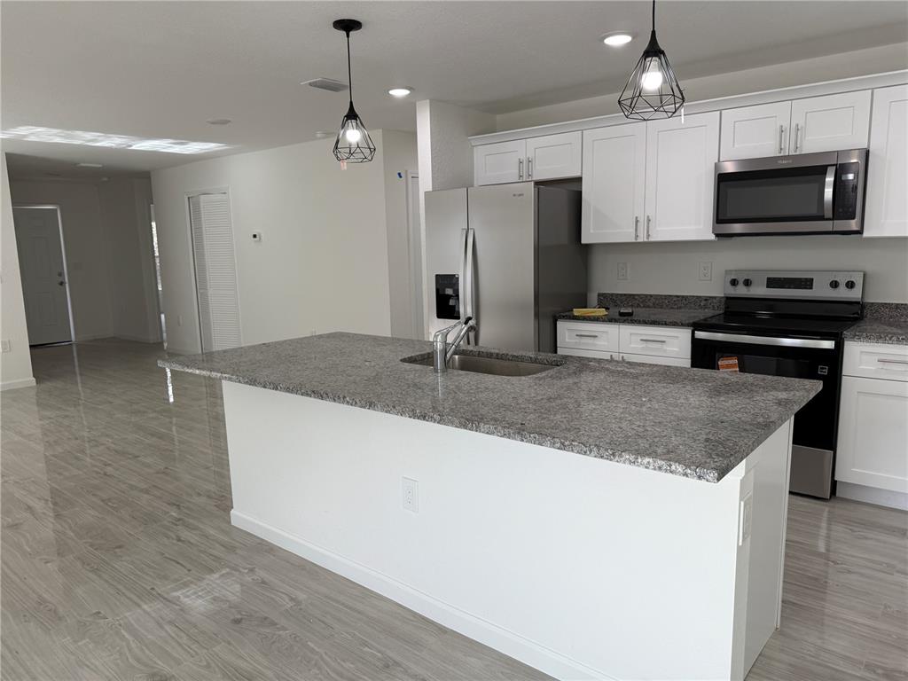 5358 Rhapsody Avenue North Port, FL 34288 - Photo 8 of 28 a kitchen with stainless steel appliances granite countertop a sink refrigerator and microwave