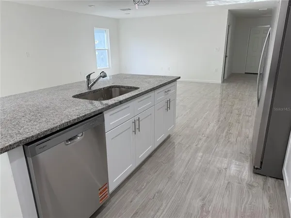 a kitchen with granite countertop a sink and cabinets