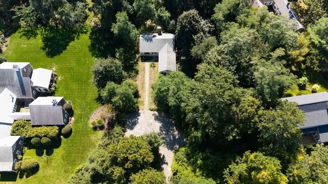 a view of a house with a yard and covered with trees