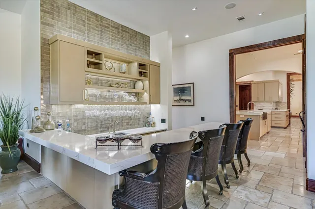 a kitchen with a sink and chairs